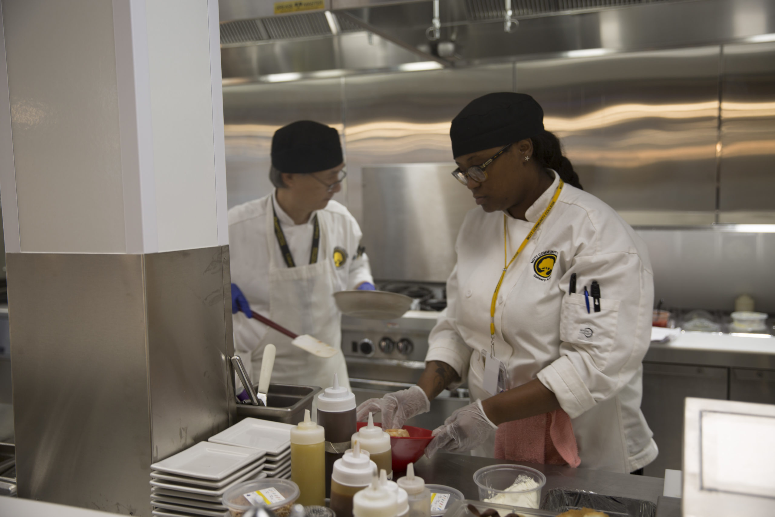 Two students of Mott Culinary school working in kitchen