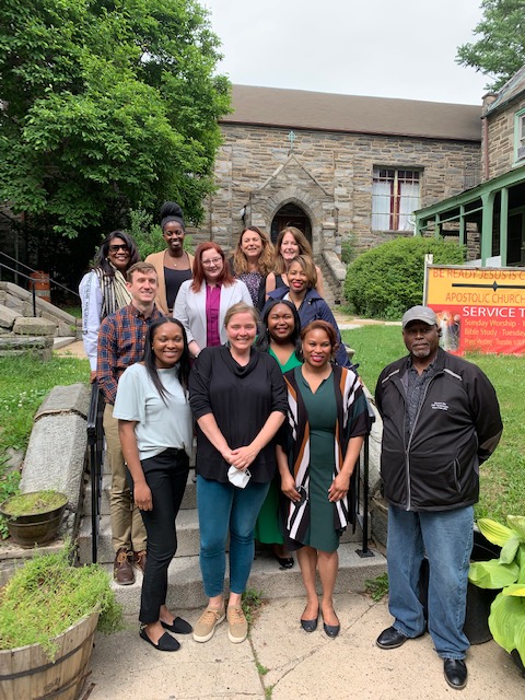 Cinnaire staff in front of a stone building in Wilm