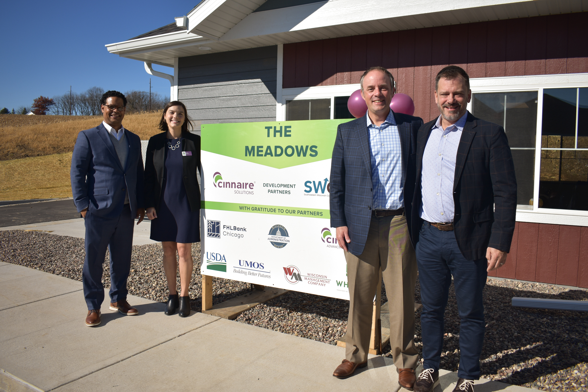 Cinnaire stafff and partners in front of The Meadows construction sign