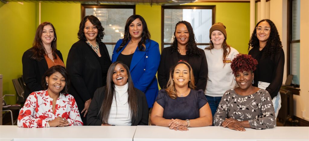 Ten women developers posing around a table