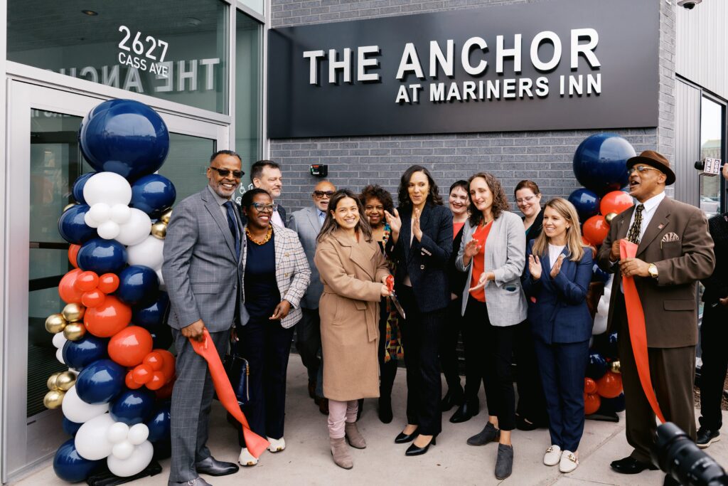 Ribbon cutting crowd in front of The Anchor at Mariners Inn sign