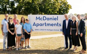 Mark McDaniel and his family in front of McDaniel Apartments sign at the grand opening ceremony