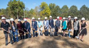 Speakers at groundbreaking event with hard hats and shovels - Wellspring